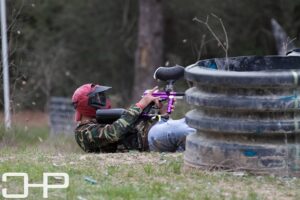 player laying on the ground and pointing paintball gun