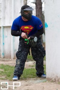 man wearing superman shirt in a paintball game