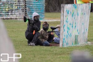 woman and boy hiding during paintball game