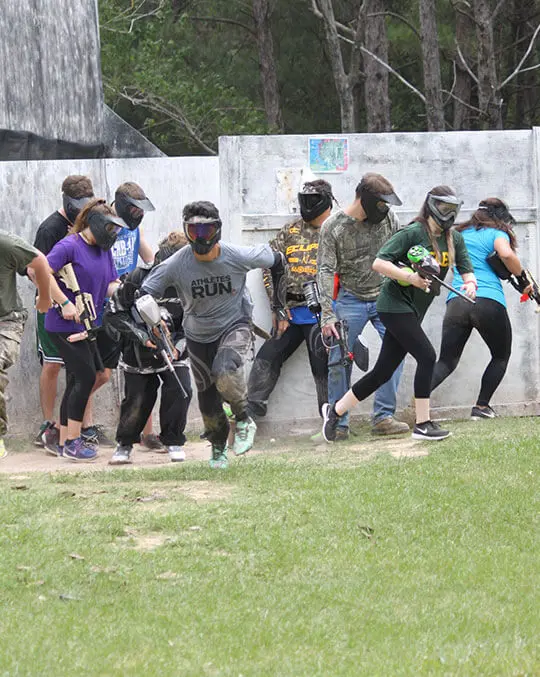 people running and playing paintball