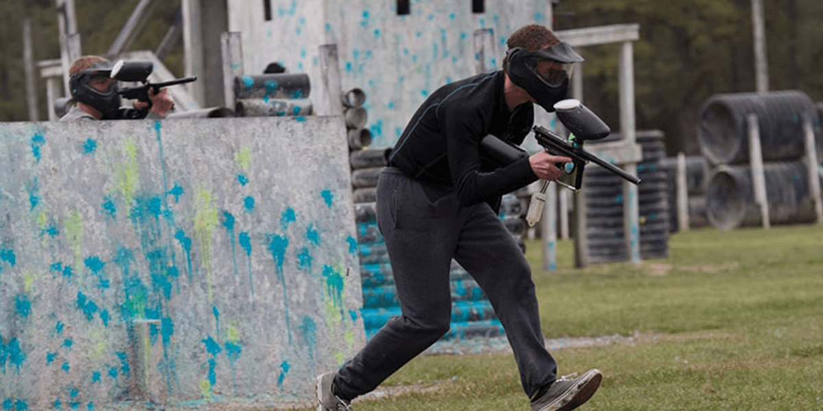 a guy running and playing paintball